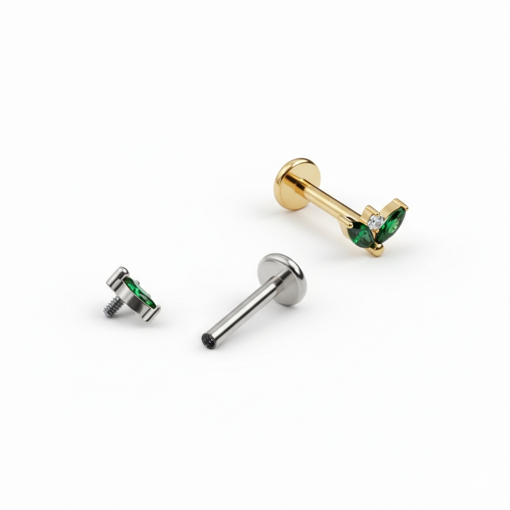 Titan-Labret mit zwei smaragdgrünen Schmucksteinen