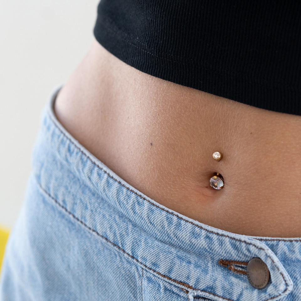 Vergoldetes Bauchnabelpiercing mit einem grossen Stein